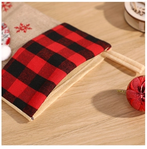 Détail du revers à carreaux rouges et noirs sur chaussette de Noël en toile de jute