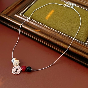Detail of silver snake chain with spotted stone beads and antique sun flower charm