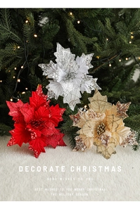 Three sequined poinsettia flowers in red, silver, and gold on a white plush surface