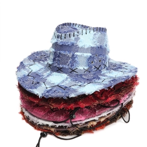 Detail of frayed edges and cross stitching on washed denim cowboy hats with chin straps