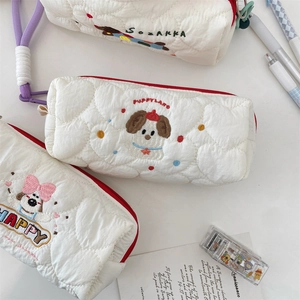 Close-up of white quilted pencil case with cute puppy embroidery and red zipper
