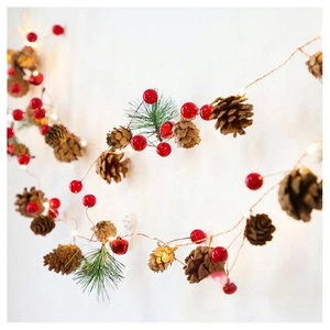 Detail of Christmas LED string lights with pine cones, red berries and festive bells