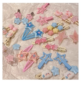 Close-up of assorted pink and blue star-shaped resin hair clips on textured white paper