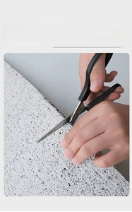 Detail of cutting white PVC coil door mat showing custom fit and durable texture