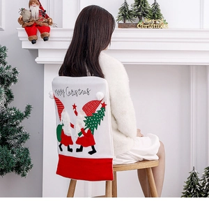 Detail of red and white Christmas chair cover featuring embroidered gnomes and Merry Christmas