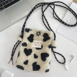 Detail of plush heart pattern mini bag with adjustable cord and brand embroidery