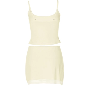 Detail of light yellow two-piece set featuring a spaghetti strap top and mini bodycon skirt
