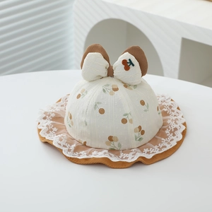 Close-up of baby sun hat featuring fruit cherry print and delicate lace trim details