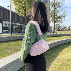 Pink quilted plush shoulder bag with golden hardware shown in an outdoor lifestyle setting