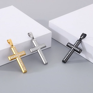 Detailed view of three stainless steel cross pendants in gold, silver, and black finishes