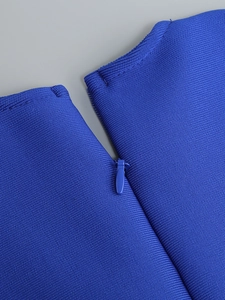 Détail d'une robe bandage bleue avec fermeture éclair invisible et texture en maille côtelée