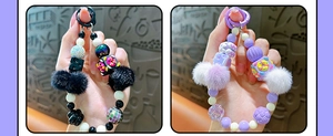 Detail van handgemaakte kralen telefoonkettingen met gekleurde blokjes en pluche pompons