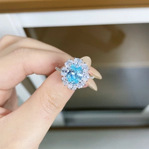 Luxurious S925 silver ring featuring a sky blue oval gemstone and white zircon petals