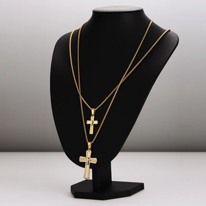 Two-tone gold and silver stainless steel cross necklaces displayed on black bust