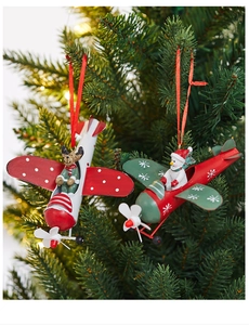 Detail of metal Christmas airplane ornaments with reindeer and snowman on a festive tree