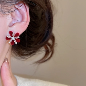 Close-up of elegant red flocked flower stud earring with pearls and zircon on model