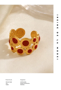 Close-up of vintage geometric ring with red enamel inlay and golden textured rings