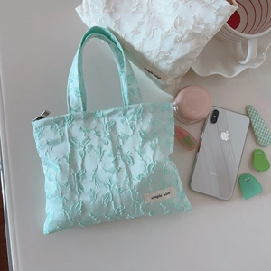 Mint green and white embossed floral mini handbags with simple wish label on plain background