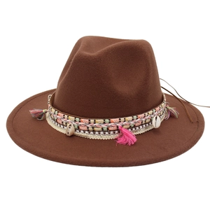 Close-up of bohemian hat band featuring colorful tassels and natural shell charms