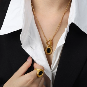 Collier doré avec pendentif en agate noire et ensemble de bagues assorties sur mannequin