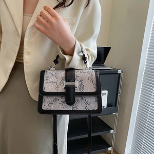 Gray floral jacquard handbag with black leather trim and silver metal buckle closure