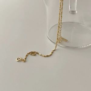 Minimalist S925 sterling silver square cube chain bracelet in gold finish shown on glass
