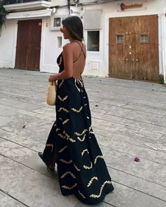 Dettaglio dell'abito boho senza schienale con motivi geometrici dorati su nero