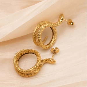 Boucles d'oreilles serpent dorées vintage avec texture d'écailles sur fond en soie