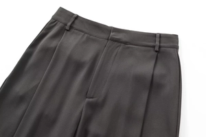 Détail du pantalon gris foncé montrant les passants de ceinture et la braguette cachée