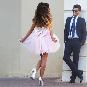 Elegant pink sequin strapless cocktail dress with a large back bow and tulle skirt