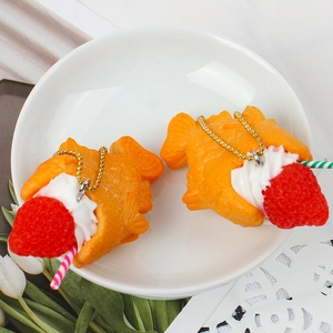 Handmade strawberry Taiyaki fish ice cream keychain with golden chain on white plate