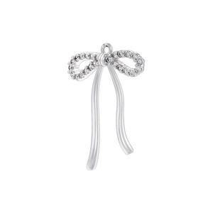 Macro detail of a silver bow pendant with shimmering rhinestones and a polished finish