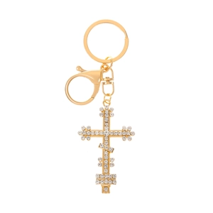 Macro detail of golden cross keychain pendant featuring high-density sparkling rhinestones
