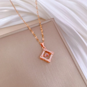 Detailed shot of rose gold necklace with diamond rhombus pendant and pink gemstone core