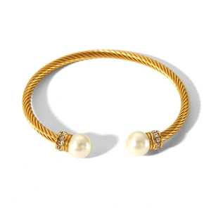 Detail of twisted cable gold bracelet featuring white pearls and rhinestone accents