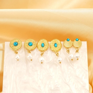 Bohemian gold-plated earrings with turquoise and baroque pearls on marble display