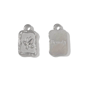Detail view of silver rectangular pendants with butterfly and Beauty engraving for DIY jewelry
