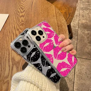 Close-up of clear iPhone cases featuring black and hot pink lip patterns held by hand