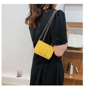 Detail of yellow heart silicone crossbody bag with gold chain and quilted texture