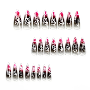 Long stiletto press-on nails with pink-black gradient and silver cross charms