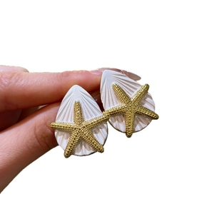 Elegante weiße Muschel-Ohrstecker in Tropfenform mit goldenem Seestern
