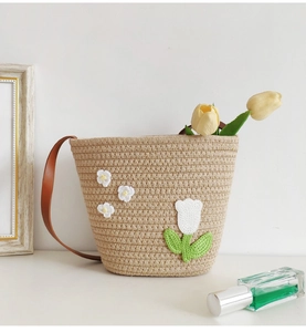 Detail of beige cotton woven tote bag featuring handmade crochet tulips and brown strap
