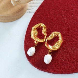 Détail des boucles d'oreilles dorées 18K aux formes irrégulières avec perles d'eau douce