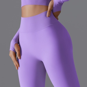 Detail of high-waisted purple yoga leggings with seamless ribbed fabric and thumbhole design