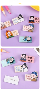 Close-up of cute acrylic badges with cartoon historical figures and inspirational quotes