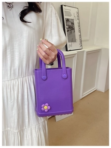Detail einer lila EVA-Tasche mit Dekoblume und Strukturierter Basis an einem Model
