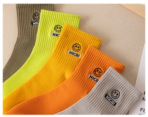 Detail of colorful cotton crew socks with smiley face and NICE tag in various shades