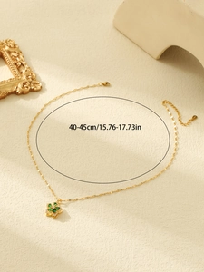 Detail of gold necklace with green flower pendant and 40-45cm length measurement