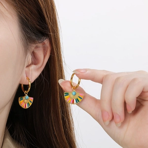 Detail of fan-shaped hoop earrings with colorful enamel and turquoise bead on model