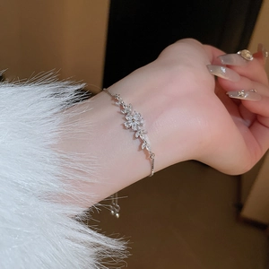 Detail view of adjustable silver flower bracelet with sparkling zircons on female wrist